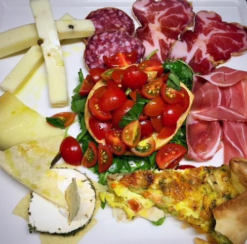 a plate of food with meats and vegetables and cheese at Hotel Forum in Baranzate