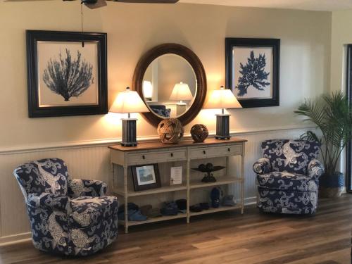 a living room with two chairs and a mirror at Surf Side Hotel in Nags Head