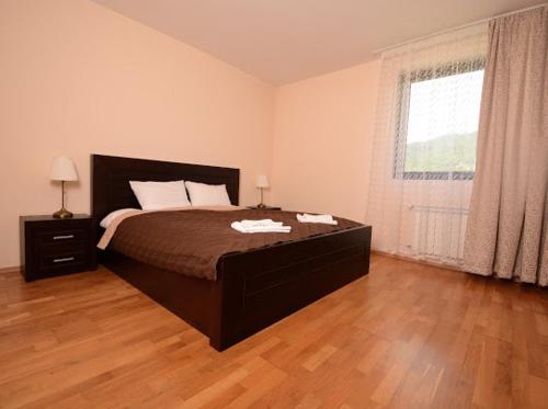 a bedroom with a bed and a large window at Pravets Resort Apartments in Pravets