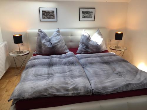 a bed with a white comforter and two side tables at Ferienwohnung Trattnig in Gassen