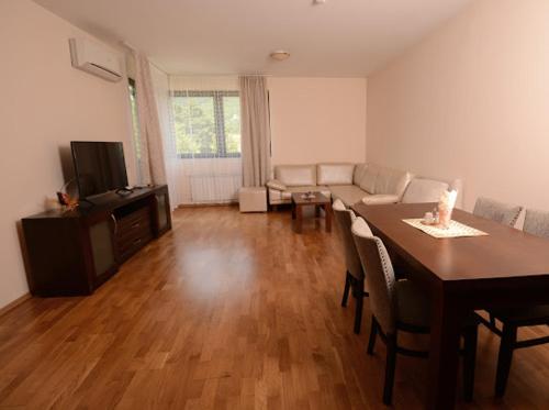 a living room with a table and a couch and a dining room at Pravets Resort Apartments in Pravets