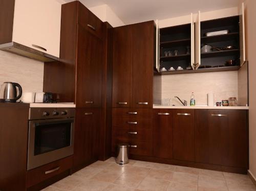a kitchen with dark wood cabinets and a stove at Pravets Resort Apartments in Pravets