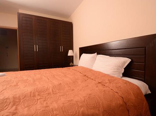 a bedroom with a large bed with an orange blanket at Pravets Resort Apartments in Pravets