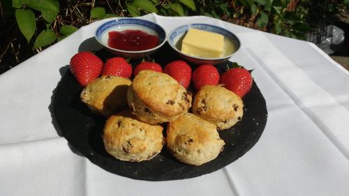 un plato de comida con fresas y mantequilla en una mesa en Doonbank Cottage Bothy, en Ayr