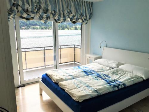 sypialnia z łóżkiem i dużym oknem w obiekcie Riva san Vitale w mieście Riva San Vitale