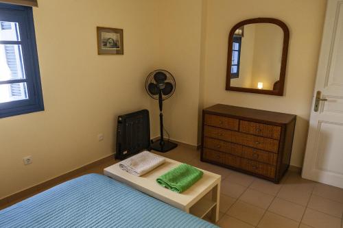 a bedroom with a bed and a dresser and a mirror at Theo's house in Chora! in Andros