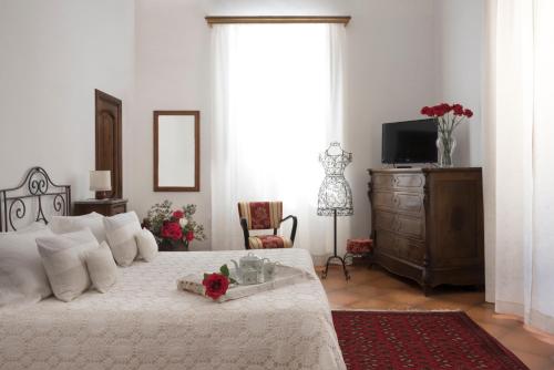 a bedroom with a bed with a dresser and a television at Malandrì B&B in Altamura