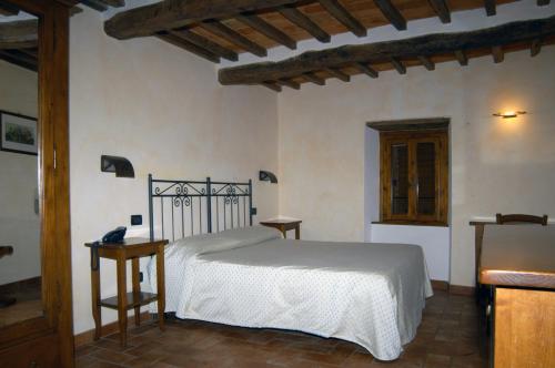a bedroom with a white bed and two tables at Buca di Michelangelo in Caprese Michelangelo