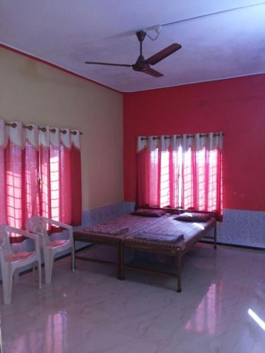 a room with a bed and red walls and windows at Greenveela Resort in Devgarh