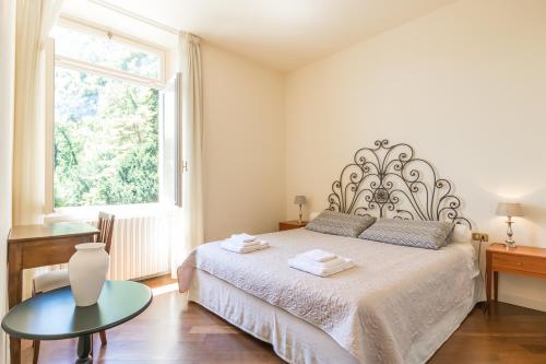 una camera da letto con un letto con un tavolo e una finestra di Apartment Anna - Griante a Griante Cadenabbia