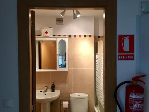 a bathroom with a sink and a toilet and a mirror at La Barquera in Ribadesella
