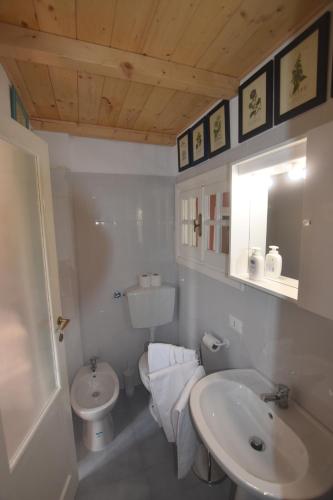 a white bathroom with a sink and a toilet at Casa di Dino alla Brusa in La Spezia
