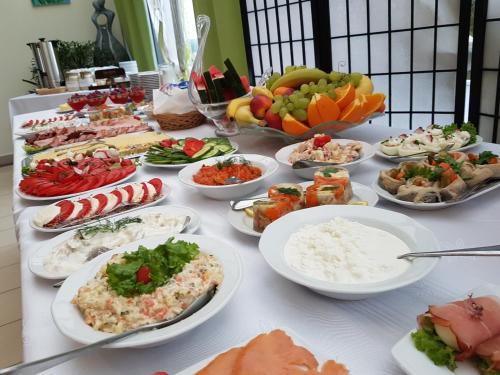 a table full of different types of food on plates at Pokoje Bakos Radocza in Radocza