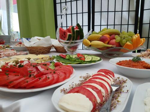 a table with plates of food and bowls of fruit at Pokoje Bakos Radocza in Radocza