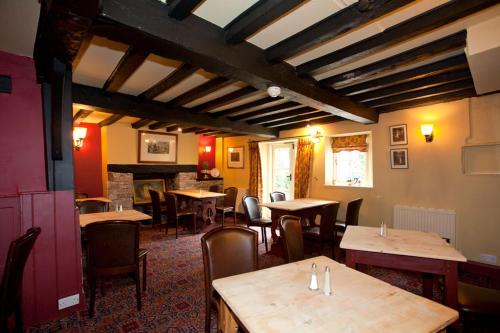 a restaurant with tables and chairs and a fireplace at The Old Black Lion in Hay-on-Wye