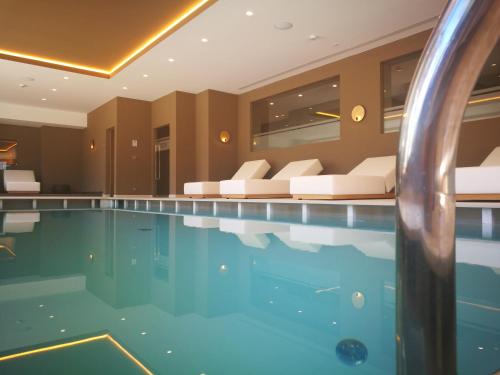 een zwembad in een hotelkamer met een bank bij Il Piccolo Dolomiti Resort in Andalo