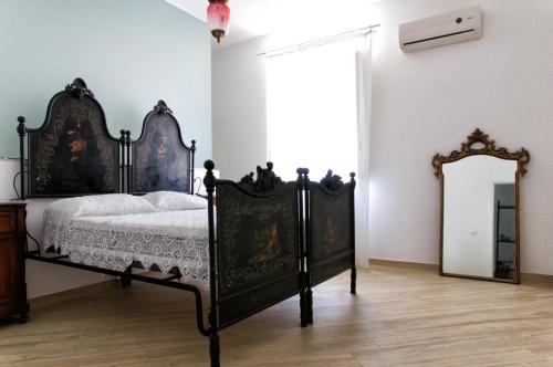 una camera con letto d'epoca e specchio di Fico d'India a Siracusa
