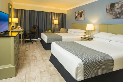 a hotel room with two beds and a flat screen tv at Krystal Urban Ciudad Juarez by US Consulate in Ciudad Juárez