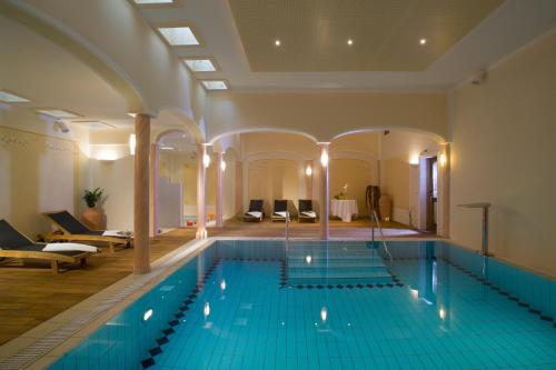 a large swimming pool in a large room with a large at Alpen Hotel Post in Au im Bregenzerwald