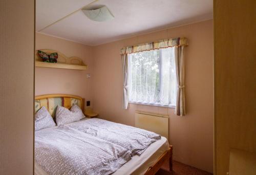 a bedroom with a bed and a window at Camping u Kukačků in Horní Planá