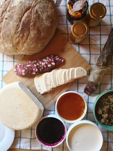 een tafel met een snijplank met kaas en brood bij Koča Ojstrica - Velika planina in Stahovica