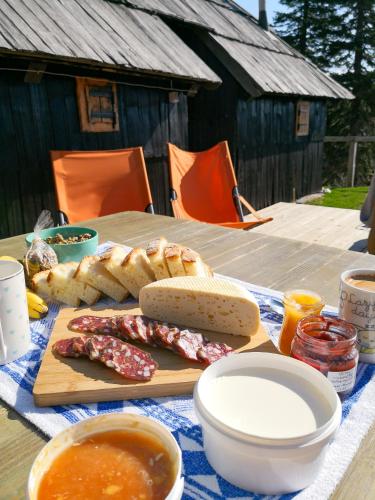 ein Picknicktisch mit Wurst, Brot und Suppe in der Unterkunft Koča Bistra - Velika planina in Stahovica