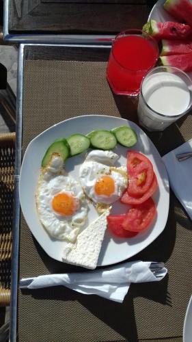 een bord eieren en groenten op een tafel bij British Hotel in Himare