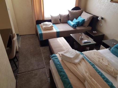 a hotel room with two beds and a couch at Stan 110 in Orašje