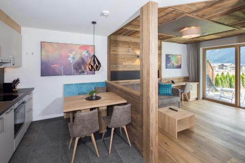 a kitchen and living room with a table and a couch at Wagner's Aparthotel in Pertisau