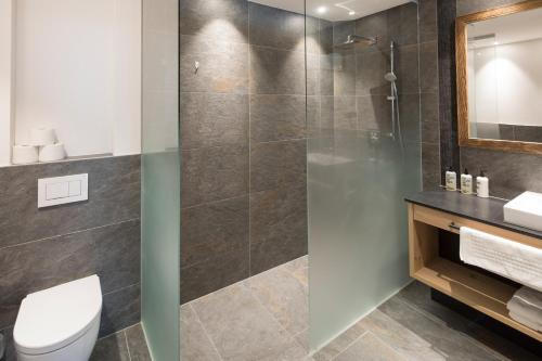 a bathroom with a shower and a toilet and a sink at Wagner's Aparthotel in Pertisau