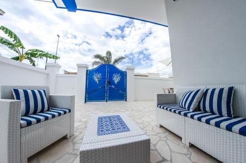 un patio con 2 sedie e una porta blu di Corallo Blu Salento a Marina di Mancaversa