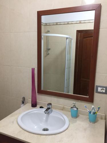 バハマルにあるÁtico con vistas espectacularesのバスルーム(大きな鏡と鏡付きの洗面台付)