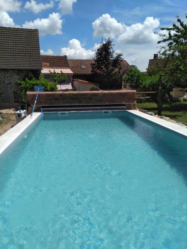 une grande piscine avec de l'eau bleue dans l'établissement Chambre d'hôtes le chat botté, à Espédaillac