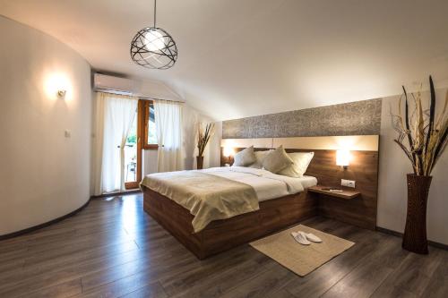 a bedroom with a large bed and a pendant light at Guest House Vana in Korenica
