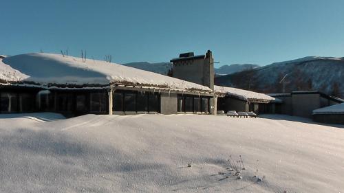 a snow covered building with a snow covered roof at Fjellkysten in Tennevoll