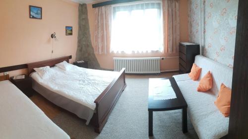 une chambre avec deux lits et un canapé et une fenêtre dans l'établissement Apartment Janka Demanova, à Liptovský Mikuláš