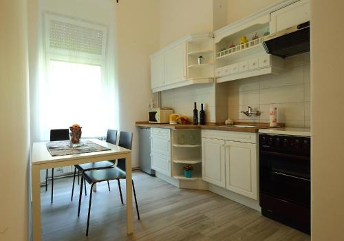 a kitchen with white cabinets and a table and a window at Palma Apartment in Zagreb