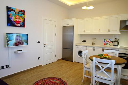 a kitchen with a table and some chairs in a room at Çeşme Kale Taş Apart in Cesme