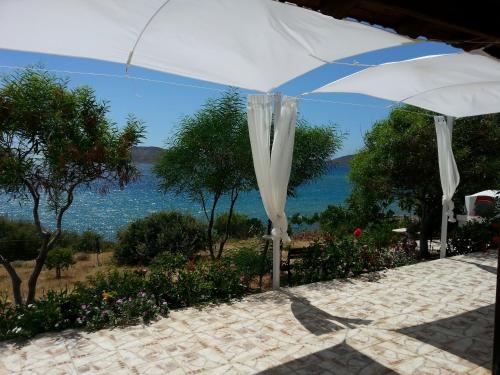 a white umbrella with a view of the water at Panormitis Pizanias houses in Skaliá