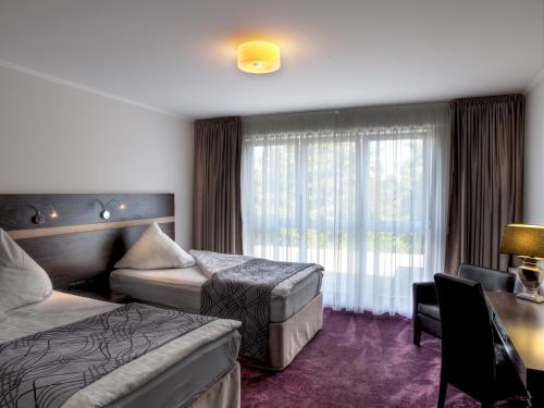 Un pat sau paturi într-o cameră la Sporthotel Racket Inn