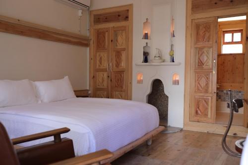 a bedroom with a white bed and a fireplace at Melekli Konak in Amasya