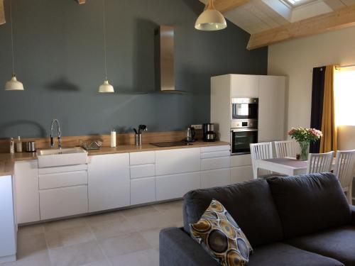 a living room with a couch and a kitchen at La grange in Machecoul