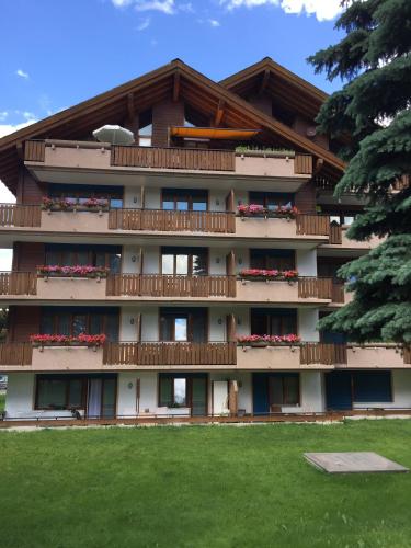 a building with balconies and red flowers on it at St Martin Apartments in Täsch