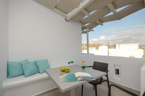 a white table and chairs on a balcony with a window at 3 Wishes in Naxos Chora