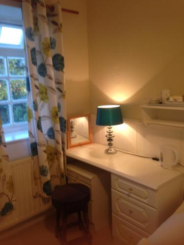 a lamp on a desk in a room with a window at Lynebank House Hotel, Bed & Breakfast in Carlisle
