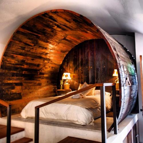 a bedroom with a large bed in a wooden wall at Hotel La Calma De Rita - Pirque in Pirque