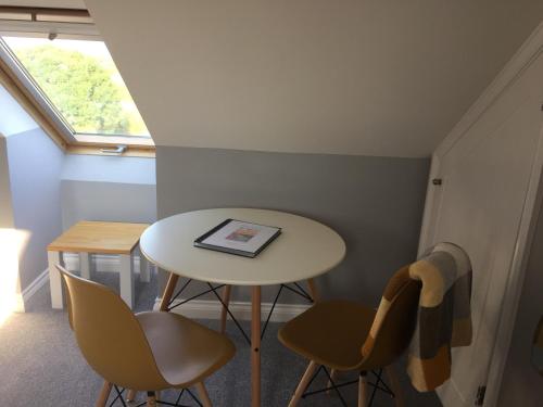 a small table and chairs in a room with a window at Rosenn Teyr in St. Agnes