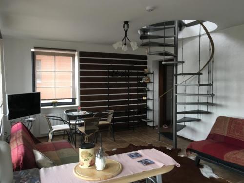 a living room with a spiral staircase and a table at Villa Traku Terasa in Trakai