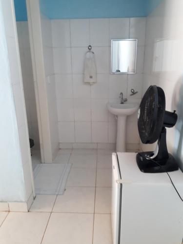 a bathroom with a sink and a fan on a counter at Pousada do Horto in Trindade