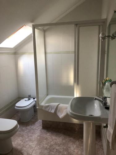 a bathroom with a tub and a toilet and a sink at Paradisiaco Umia in Meis